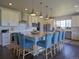 Modern kitchen features a granite island with pendant lights, bar stools, and stainless steel appliances at 609 Pioneer Camp Vw, Palmer Lake, CO 80133