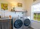 Bright laundry room featuring stainless steel washer and dryer with a sink and storage at 609 Pioneer Camp Vw, Palmer Lake, CO 80133