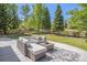 Inviting backyard patio with comfortable outdoor seating, a stylish rug, and a view of the lush, green lawn at 19096 W 53Rd Pl, Golden, CO 80403