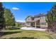 Expansive backyard with a well-manicured lawn, solar panels, mature trees, a patio, and a charming wooden fence at 19096 W 53Rd Pl, Golden, CO 80403