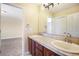 Bright bathroom featuring double sinks, tile countertops, and a large mirror at 19096 W 53Rd Pl, Golden, CO 80403