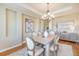 Dining room with tray ceiling, chandelier, plantation shutters, and an adjacent buffet at 19096 W 53Rd Pl, Golden, CO 80403