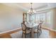 Dining area featuring tray ceiling, chandelier, plantation shutters and hardwood floors at 19096 W 53Rd Pl, Golden, CO 80403