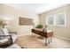 Cozy office space featuring a sleek wooden desk, stylish armchair, and ample natural light from the shuttered window at 19096 W 53Rd Pl, Golden, CO 80403