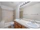 Bathroom featuring dual sinks, a large mirror, a tub with tile surround, and stylish lighting at 12710 Jasmine St # C, Thornton, CO 80602