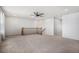 Bright bonus room with neutral carpet, a ceiling fan, and staircase with wood banister at 12710 Jasmine St # C, Thornton, CO 80602