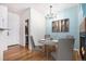 Stylish dining area with modern chandelier, hardwood floors, and adjacent living space at 12710 Jasmine St # C, Thornton, CO 80602