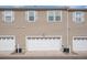 Exterior view of garages, each featuring a door and air conditioning units outside at 12710 Jasmine St # C, Thornton, CO 80602