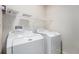 Functional laundry room with a washer, dryer, and overhead shelving for storage at 12710 Jasmine St # C, Thornton, CO 80602