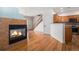 Living area with hardwood floors, fireplace, open to kitchen, and staircase access to upper level at 12710 Jasmine St # C, Thornton, CO 80602