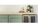 Bar area featuring light green cabinets and a built-in wine fridge with glass doors at 4631 Zuni St, Denver, CO 80211