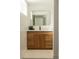 Modern bathroom vanity with a wooden finish, gold mirror frame, and black faucet, blending style and functionality at 4631 Zuni St, Denver, CO 80211