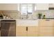 A bright kitchen featuring a farmhouse sink, stainless steel appliances, and wooden cabinets at 4631 Zuni St, Denver, CO 80211