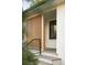 Stylish porch features vertical wood slats, sleek black railings, and painted white brick at 4631 Zuni St, Denver, CO 80211