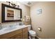 Cozy half bathroom with a vanity, toilet, and decorative mirror at 4250 S Olive St # 108, Denver, CO 80237