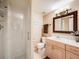 Well-lit bathroom featuring a walk-in shower and vanity with stylish fixtures and countertop at 4250 S Olive St # 108, Denver, CO 80237