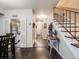 Inviting entryway featuring dark wood floors and a staircase with decorative iron railings at 4250 S Olive St # 108, Denver, CO 80237