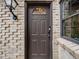 Close-up of an elegant front door with decorative window details and a stylish wall-mounted light fixture at 4250 S Olive St # 108, Denver, CO 80237