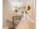 Hallway with hardwood floors, staircase, and a decorative chandelier at 4250 S Olive St # 108, Denver, CO 80237