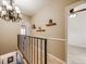 Upstairs hallway with hardwood floors, wrought iron railing and decorative wall shelves at 4250 S Olive St # 108, Denver, CO 80237