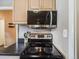 Kitchen detail highlighting the range, microwave, and dark countertop at 4250 S Olive St # 108, Denver, CO 80237