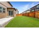 Gorgeous backyard with a sprawling green lawn, patio, and fenced in perimeter at 933 Canal West Dr, Brighton, CO 80603