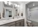 Bathroom featuring double sinks, a shower-tub combo, and a doorway to the laundry room at 933 Canal West Dr, Brighton, CO 80603