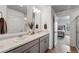 Clean bathroom with double vanity, grey cabinets, modern lighting, and access to the bedroom and shower at 933 Canal West Dr, Brighton, CO 80603