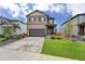 Charming two-story home featuring a well-manicured lawn, complemented by an attached two-car garage and a welcoming front porch at 933 Canal West Dr, Brighton, CO 80603