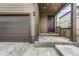 Home exterior featuring a covered entrance, a garage, and concrete entryway at 933 Canal West Dr, Brighton, CO 80603