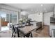 Open-concept kitchen and dining area with stainless steel appliances, gray cabinets, granite counters, and wood floors at 933 Canal West Dr, Brighton, CO 80603