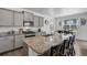 Modern kitchen with stainless steel appliances, gray cabinets, granite countertops, and a breakfast bar with seating at 933 Canal West Dr, Brighton, CO 80603