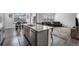 Kitchen with a large island, stainless steel appliances, wood floors, and open view to dining and living areas at 933 Canal West Dr, Brighton, CO 80603