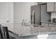 Close up view of kitchen with stainless steel sink, granite countertops, and gray cabinets with stainless steel fridge at 933 Canal West Dr, Brighton, CO 80603