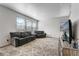 Comfortable living room with neutral carpet, gray sofas, and large windows for plenty of natural light at 933 Canal West Dr, Brighton, CO 80603