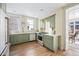 Bright kitchen with stainless steel appliances, custom green cabinets, and refinished hardwood floors at 1368 N Gilpin St, Denver, CO 80218