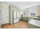 Modern kitchen with stainless steel appliances, custom green cabinets, and refinished hardwood floors at 1368 N Gilpin St, Denver, CO 80218