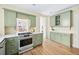 Bright kitchen with green custom cabinets, white countertops, and modern stainless steel appliances at 1368 N Gilpin St, Denver, CO 80218