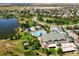An aerial view of a community clubhouse, pool, and surrounding lush landscape with trees near a lake at 16371 Jones Mountain Way, Broomfield, CO 80023