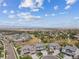 An aerial view of a residential neighborhood with walking paths, manicured lawns, and distant mountain views at 16371 Jones Mountain Way, Broomfield, CO 80023