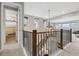 Bright hallway featuring an open staircase with a modern chandelier and an open doorway to a bathroom at 16371 Jones Mountain Way, Broomfield, CO 80023