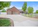 Beautifully landscaped brick home with a long driveway and white fencing at 3784 Whitetail Ct, Mead, CO 80542