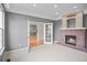 Inviting living room with a cozy brick fireplace, neutral carpet, and bright light with french doors at 3784 Whitetail Ct, Mead, CO 80542