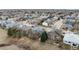 Wide aerial shot shows homes in a community setting with lawns and mature trees at 664 Clarendon Dr, Longmont, CO 80504