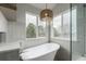 Bathroom featuring a soaking tub with views of the outside and a frameless glass shower at 664 Clarendon Dr, Longmont, CO 80504