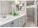Bathroom with double vanity, white cabinetry, modern lighting, and tub/shower combo at 664 Clarendon Dr, Longmont, CO 80504