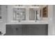 Elegant bathroom with dual sinks, marble countertops, sleek gray cabinetry and updated lighting at 664 Clarendon Dr, Longmont, CO 80504