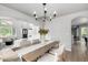 Bright dining room with modern chandelier and open floor plan flows to a living room and staircase at 664 Clarendon Dr, Longmont, CO 80504
