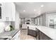 Open kitchen with an island featuring a farmhouse sink, stone countertops, and view into the living room at 664 Clarendon Dr, Longmont, CO 80504