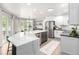 Bright, open kitchen with an island, stone countertops, stainless steel appliances, and backyard view at 664 Clarendon Dr, Longmont, CO 80504